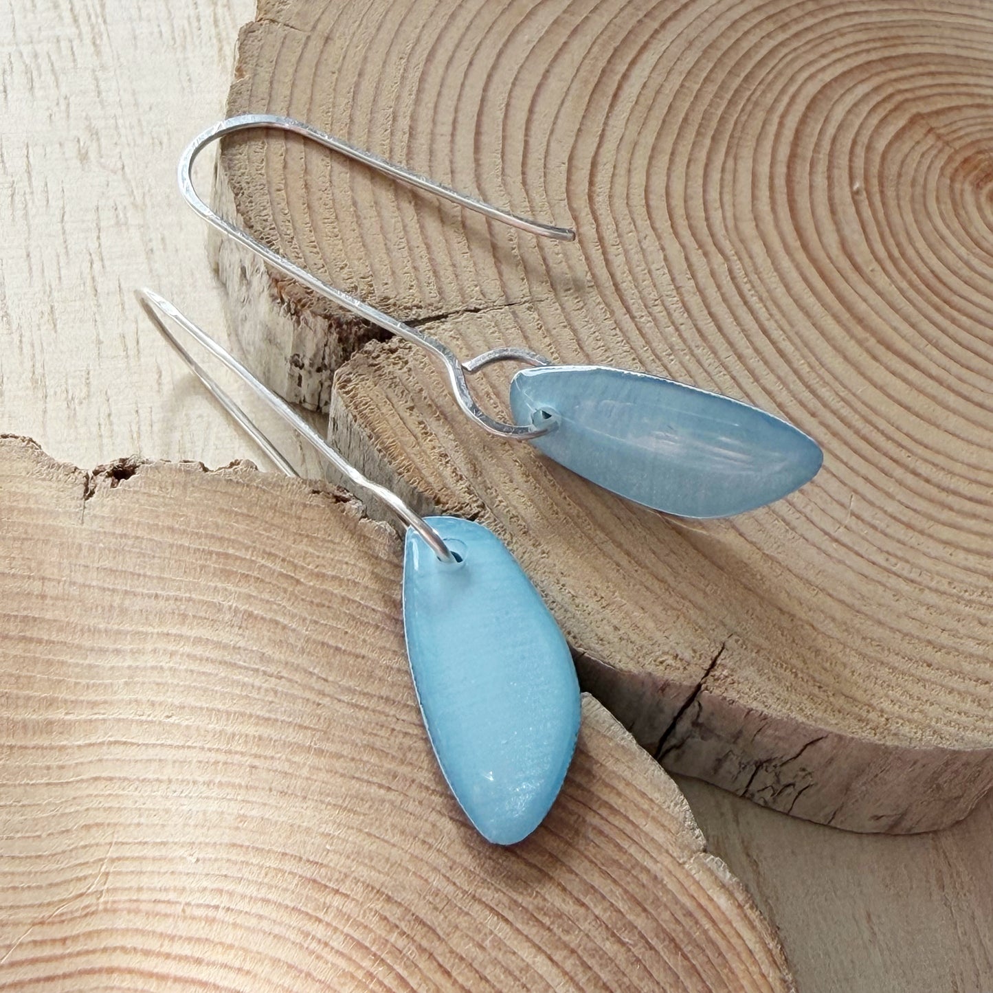 Blue teardrop earrings on a wooden surface